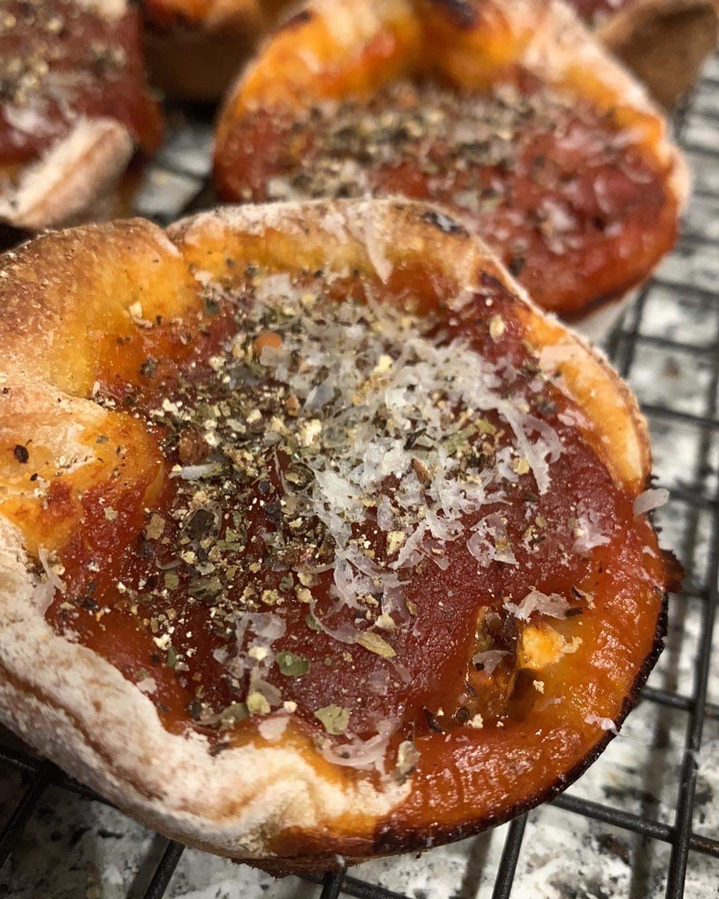 Deep dish pizza muffins topped with parmesan and herbs